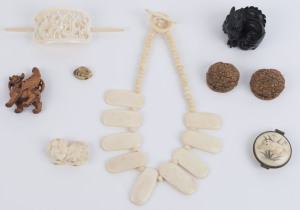 Carved bone necklace, Chinese carved ivory hair pin, two carved timber dragon statues, Chinese carved ivory dog, Japanese pill box, bead and carved walnut shells, 19th and 20th century, (9 items), the hair pin 13cm wide