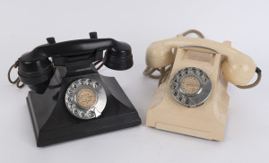 Two vintage telephones, one black bakelite with out swept case, the other white bakelite with moulded case and steel carrying handle. Together with two spare handsets, wires, dialing mechanism and valve globes. The larger 17cm high