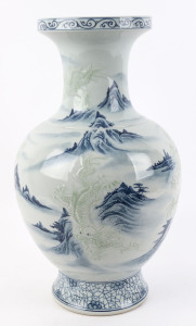 A Chinese blue and white porcelain mantel vase with embossed celadon dragons in mountain landscape, 20th century, square seal mark to base, 53cm high