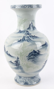 A Chinese blue and white porcelain mantel vase with embossed celadon dragons in mountain landscape, 20th century, square seal mark to base, ​53cm high