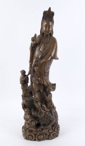 A Chinese carved wooden statue of Guanyin standing on a water dragon holding a pearl, 20th century, 84cm high