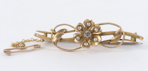 An 18ct gold bar brooch with floral design set with diamond and seed pearls, early 20th century, stamped "18ct" with inscription "Father, Sep, 20, '05", ​4.5cm wide, 5.5 grams