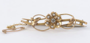 An 18ct gold bar brooch with floral design set with diamond and seed pearls, early 20th century, stamped "18ct" with inscription "Father, Sep, 20, '05", ​4.5cm wide, 5.5 grams