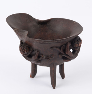 A Chinese carved bamboo libation cup adored with three Chi-long dragons and archaic style tripod base, Qing Dynasty, 19th century, 11cm high, 14.5cm wide