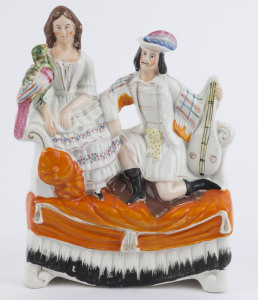 A Staffordshire pottery figural group of a couple on a settee with lute and parrot, 19th century, 25.5cm high