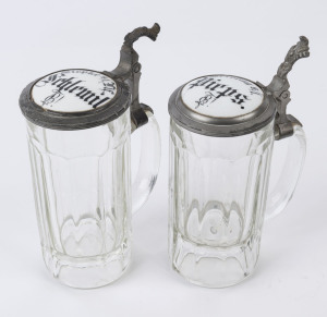 A pair of German antique beer steins, pressed glass with pewter mounted porcelain button tops, 19th century, ​19cm high