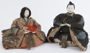 JAPANESE DOLLS: seated Emperor and Empress 'Hina' dolls in traditional dress with carved wooden heads and hands, bodies constructed from multi-layered textiles and washi paper stuffed with straw; the male's dress is heavily worn; height 29cm (male) & 26cm