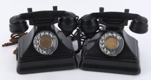 A pair of English black bakelite telephones with moulded and stepped bases, mid 20th century, 18cm high
