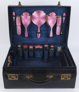 A vintage travel set, English sterling silver and pink enamel in original black leather fitted case, early 20th century, the case 51cm wide