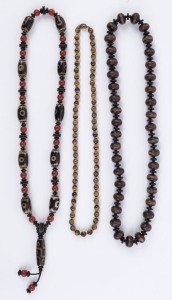 Three Sino-Tibet bead necklaces including tiger's eye, carnelian, glass etc, 19th and 20th century, the largest 60cm long