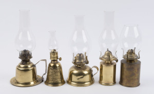 Five brass kerosene lamps, one with pressed floral decoration and two with carrying handles, each with single brass burners and glass chimneys, early 20th century, (5 items), the taller 28cm high