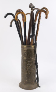 Eleven assorted walking sticks, 19th and 20th century; together with an embossed brass stick stand, the largest 93cm high