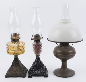 Three antique oil lamps, 19th and early 20th century, one with amber font, one with cut crystal font and the other with metal font, ​the largest 50cm high
