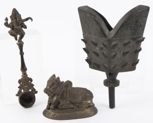 An antique Tibetan bronze bell with incised and horned decoration; a Tibetan bronze Ganesh ladle; and an Indian bronze cow statue, 19th century, (3 items), the bell 25cm high