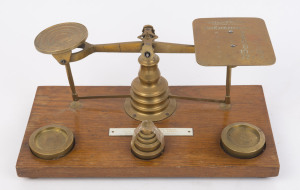 Antique brass postal scales on timber base with weights, 19th century, ​30.5cm wide