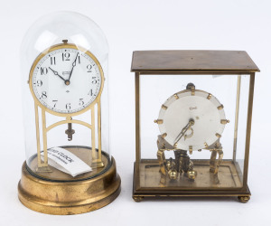 TIFFANY "Never Wind" American brass anniversary clock with white enamel dial and electric operated movement under glass dome, (missing pendulum); together with a KUNDO German 400 day anniversary clock with silvered dial and brass frame under a 4 glass cas