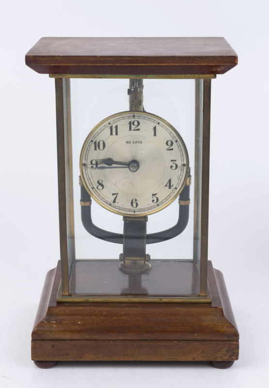 BULLE, 800 DAYS French mantel clock, early 20th century, Mahogany and brass framed cased with glassed sides on ogee moulded plinth with three squat bun feet. Silvered brass dial with printed Arabic numerals and minute track with blued steel spade hands,