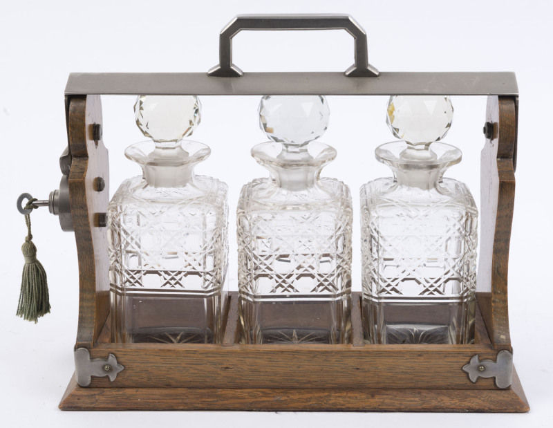 An antique English tantalus set, oak and nickel plate with three decanters, late 19th century, ​29cm high, 38cm wide