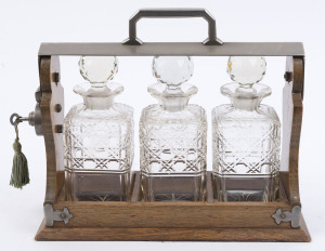 An antique English tantalus set, oak and nickel plate with three decanters, late 19th century, 29cm high, 38cm wide