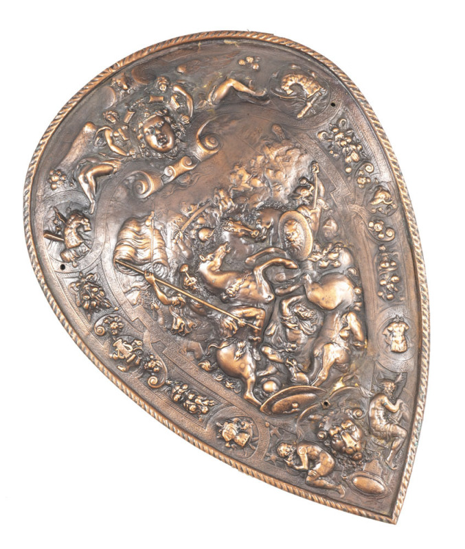 EXCEPTIONAL PIN SHAPED BRONZE PARADE SHIELD: 25" x 17½" & weighing 6.165kgs; depicting Roman cavalry, Medusa, winged maidens, rampant horse, rams head, flags, swords & battle scene; roped borders. A great decorator.