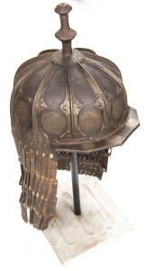 RARE SUMO-TIBETAN SIEGE TYPE IRON HELMET: domed skull formed of 10 overlapping embossed plates to form raised ribs, each plate having a silver inlaid mon type tailman to the bottom edge; the top fitted with a moulded baluster shaped finial; angular peak t