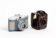 BILORA (Germany): Boy, c1950 brown bakelite box camera for 127 film, the "BOY" in gold. Also, a Bella D, c1956, 127 film camera in blue-grey with chrome top; in maker's ERC. (2 cameras)