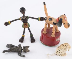 FIGURINE SELECTION: comprising metal figure of a West African native with flexible coiled-wire neck and limbs, height 12cm; "Dismal Desmond" celluloid dalmatian dog (missing tail), pull-out tape measure, height 4.5cm; Tri-ang/Wakouwa wooden dog push/tumbl