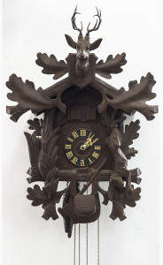 A German Black Forest Cuckoo clock with oakleaf and animal carved case, 20th century. Dial marked "Made in Germany" with twin pinecone weight driven movement, twin bellows, music box and automata cuckoo and huntsman. 52cm high.