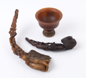 A carved horn wine cup, (19th century); together with a carved horn Ruyi sceptre with mushroom finial and Chi-Long dragon handle (19th century; as well as a carved horn sceptre adorned with leaves and peaches, (19th century), (3 items), the cup 9cm high, 10cm diameter, the sceptres 19.5cm and 28cm long