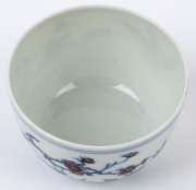 Two Chinese porcelain teacups with Doucai decoration with birds and blossoms in landscape, 19th/20th century, Yongzheng underglaze blue six character mark, 4cm high - 7