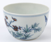 Two Chinese porcelain teacups with Doucai decoration with birds and blossoms in landscape, 19th/20th century, Yongzheng underglaze blue six character mark, 4cm high - 9