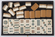A Chinese marine ivory and bone Mah-jong set in a hardwood table cabinet with a sliding door opening to reveal five drawers with a complete set of hand painted pieces. The hardwood box has double bronze handles. Chinese character marks with the original o - 10