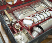 A stunning early automotive picnic set by "EDWARDS & SONS, REGENT STREET, LONDON", early 20th century, comprising stainless steel, enamel and silver plated cutlery, cannisters, warmers, containers etc., the case 62cm wide - 7