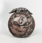 An Australian paperweight, spherical marble with applied silver platypus, 20th century, stamped "STG. SIL. M. HAMMOND", ​9cm high