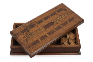An Australian games box with cribbage top and fold-over chess board, silky oak, cedar, Queensland walnut and pollard oak, 19th century, with accompanying draughts pieces and three carved whale bone dice, 8.5cm high, 31cm wide, 15.5cm deep