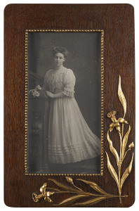 A full length portrait studio photograph of a young woman (possible in her wedding dress?), circa 1900, in a period oak frame with applied gilt floral decoration. Overall 53 x 34cm.