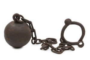 A convict ball and chain with riveted leg shackles, early 19th century, 108cm long, ball diameter 12cm