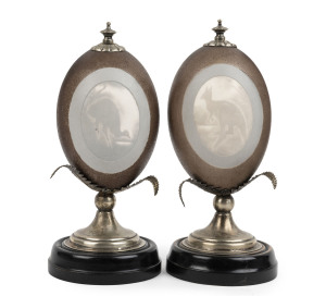 A pair of carved emu egg mantel ornaments, mounted in silver plate with ebonized base, late 19th century, 21cm high