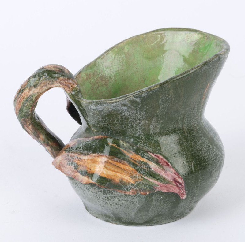 OPPERMAN (HARVEY SCHOOL) green glazed pottery jug with applied gum leaves and branch handle, incised "Hand Built. Opperman, 1937", ​10cm high, 13cm wide