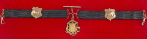 15ct gold fob (soldier on shield with boomerang, kangaroo and emu) suspended from a black silk band together with two 9ct gold shields and links (approx. 10gms total). The fob, engraved verso "Presented to Pte. A.W. McCullough, 21st Batt. A.I.F. by the Ci