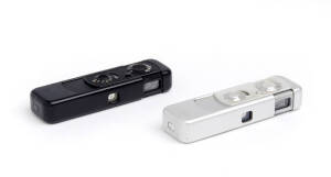 MINOX (Germany): Minox III-S sub-miniature camera in black, 1962, [#145068 - feet & inches] in leather case with chain. Also, a Minox III-S in chrome, 1956-57, [#117349 - feet & inches] also in a leather case with chain. (2 cameras).