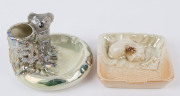 WEMBLEY WARE ashtrays, one example with dog decoration and the other with koala decoration, impressed factory marks to base, the koala ashtray 14cm wide. (2).