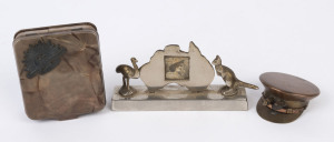 A trench art cigarette lighter in the form of an officer's cap, a decorated tin with rising sun badge, and an Australian chrome picture frame with emu and kangaroo, early to mid 20th century, (3 items), the picture frame 12.5cm wide