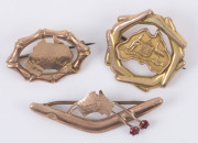MAPS OF AUSTRALIA: Three different 9ct gold brooches, all featuring maps of Australia, one surrounded by boomerangs, one with the map over a boomerang, and one other; early 20th century. (3). Total weight: 5.5gms.