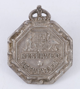 "RESERVED OCCUPATION" white metal badge by Wallace Bishop, dated 1940 verso. Issued to persons in reserved occupations who had volunteered to serve with any service if called upon at any time during the war (but who were deemed to be required to remain at