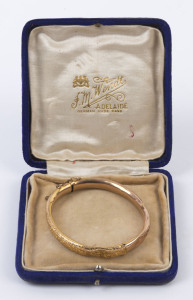 A lady's antique 9ct gold bangle with engraved decoration, late 19th century, 7cm wide, 6.6 grams total. Housed in plush velvet box branded "J.M. WENDT, ADELAIDE",