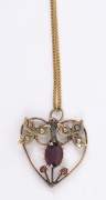 An Edwardian 9ct gold pendant set with garnet and seed pearls, circa 1910, with a later chain. The pendant 2.5cm high - 2