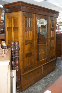 An Australian Arts & Crafts wardrobe, fiddleback blackwood with copper strap hinges and fine repoussé panels, circa 1900, 230cm high, 216cm wide, 71cm deep