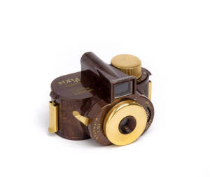 WHITTAKER (U.S.A.): Pixie Custom, c1950, sub-miniature camera for 16mm film in special cassettes; the marbelized brown plastic body and gold-plated metal parts. In small plastic display packaging and accompanied by the maker's leather case. The last recor