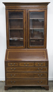 An English Sheridan style bureau bookcase, flame mahogany with satinwood and ebony inlay, Queen Elizabeth II impressed stamp on the back, mid 20th century, interior attractively fitted with drawers, pigeonholes and secret compartments, 223cm high, 119cm w